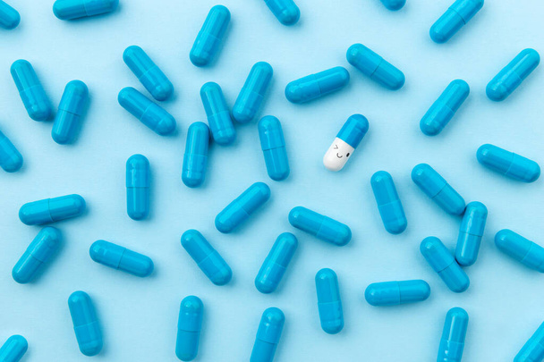 Pillole mediche su sfondo blu. Top view flat lay integratori biologicamente attivi. Concetto di trattamento sanitario - Foto, immagini