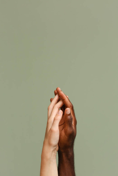 Biała kobieta i Afroamerykanin trzymający się za ręce na tle koloru. Koncepcja rasizmu - Zdjęcie, obraz