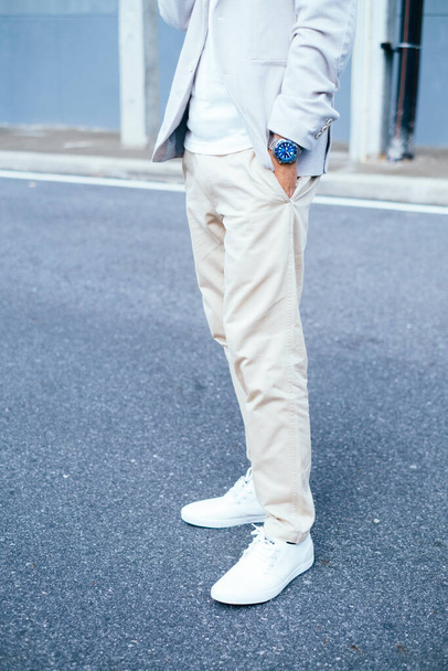 Cropped image of man's legs in white pants while standing on the road. - Fotó, kép