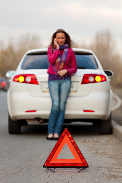 Femme appelle à un service debout près d'une voiture blanche
 - Photo, image
