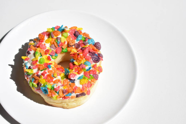 Смачний і красивий пончик, барвистий пончик з кукурудзяних пластівців, ізольований, білий фон, вид зверху, нездорове харчування, фаст-фуд, домашня, солодкий, випічка, сніданок, солодкий, смачний
 - Фото, зображення