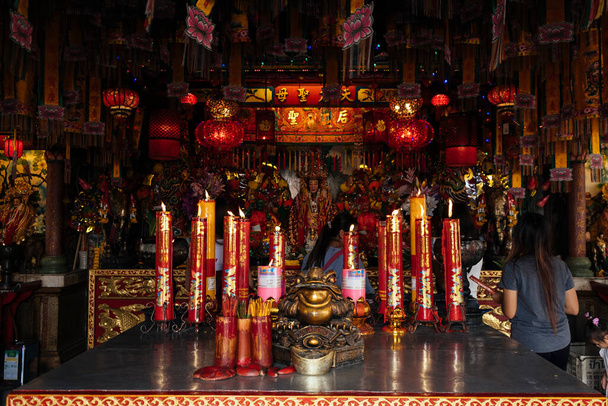Ihmiset rukoilevat sisällä Kiinan temppeli paljon punainen kynttilä ja lamppu. - Valokuva, kuva