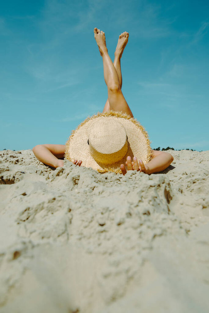 woman laying at sand beach crossing legs up summer vacation - Photo, Image