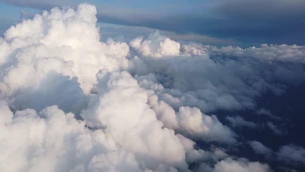 Zicht op wolken en de zonne-hemel van boven uit het vliegtuig. Wolken in het raam. Het uitzicht vanuit het vliegtuig. - Video