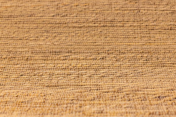 Blurry texture of hard wicker brown natural rug. Focus with shallow depth of field. - Fotó, kép