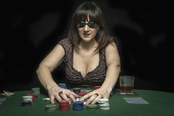 Attractive woman collects his winnings in a game of poker - Photo, Image