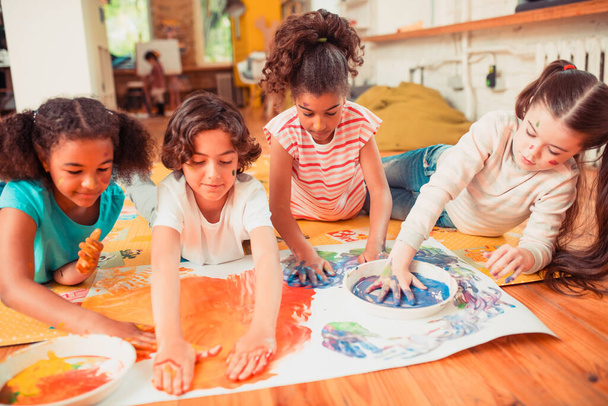 Children creating a bright picture with their hands - 写真・画像