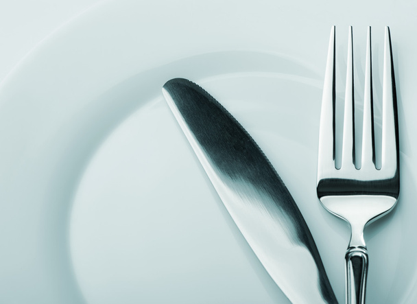Knife and fork on a plate - Фото, зображення