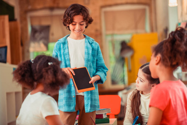Boy showing a tablet to his classmates - Фото, зображення