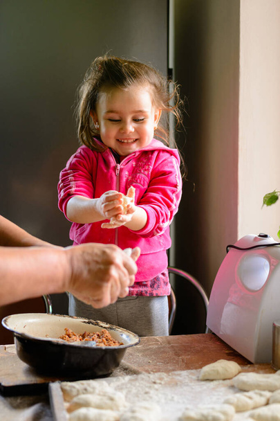 Otthon az unoka és a nagymama gombócot főz a konyhában. Nachika húsból, az unoka boldog, hogy a nagymamája tanít. - Fotó, kép
