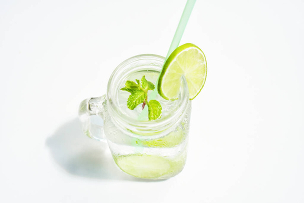 Einmachglas Limonade mit grüner Zitronenscheibe und Minzblatt, Honig isoliert auf weißem Hintergrund, Sommergetränk, frisch, Getränk, hausgemacht, kühl, Fruchtsaft, Seitenansicht - Foto, Bild