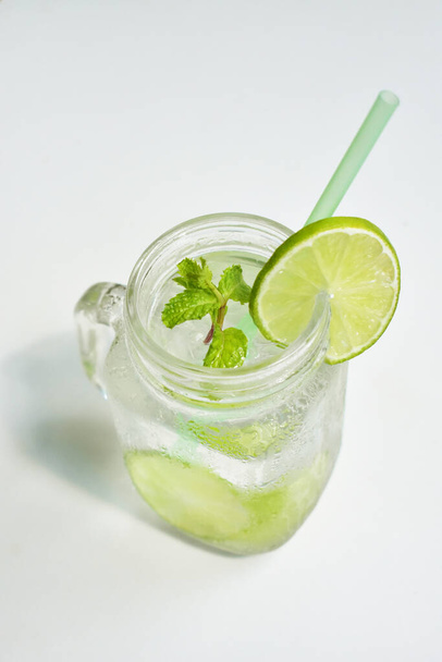 Einmachglas Limonade mit grüner Zitronenscheibe und Minzblatt, Honig isoliert auf weißem Hintergrund, Sommergetränk, frisch, Getränk, hausgemacht, kühl, Fruchtsaft, Seitenansicht - Foto, Bild
