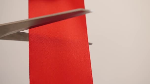 Cutting of red ribbon on light background - Footage, Video
