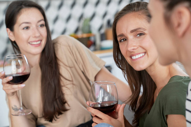 Οι φίλοι περνάνε χρόνο μαζί πίνοντας κρασί. - Φωτογραφία, εικόνα