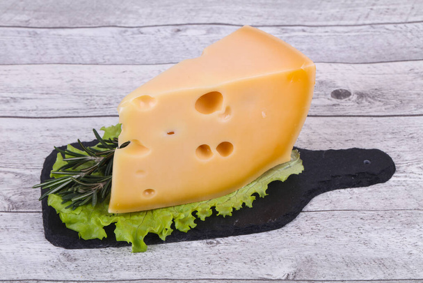 Maasdam-Käse auf dem Brett serviert Salatblätter und Rosmarin - Foto, Bild