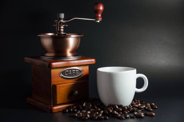 valkoinen kahvikuppi ja kahvimylly ja kahvipavut mustalla pohjalla - Valokuva, kuva