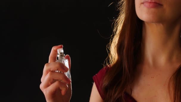 Young woman with perfume on dark background, closeup - Footage, Video
