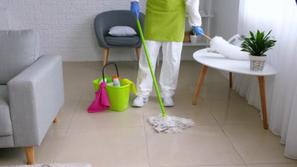 Ama de casa en la sala de limpieza traje de protección y hablando por teléfono
 - Metraje, vídeo