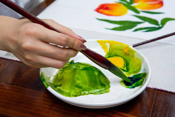 An artist painter is creating a Chinese painting, dipping paint with a brush - Photo, Image