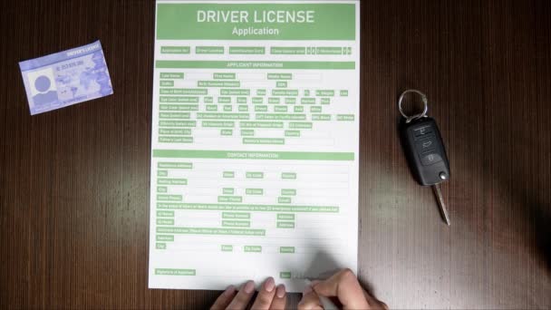 Mujer llenando la solicitud de licencia de conducir en la mesa, vista superior
 - Metraje, vídeo
