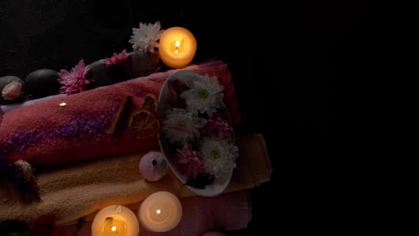 Hermosa composición de spa con toallas de algodón y flores sobre fondo oscuro
 - Imágenes, Vídeo