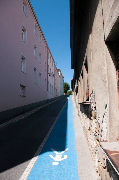 Узкая улица с голубой пешеходной дорожкой в городе Изола, Словения. Глубокий взгляд. - Фото, изображение