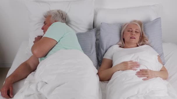 Reifer Mann im Bett mit schnarchender Ehefrau - Filmmaterial, Video