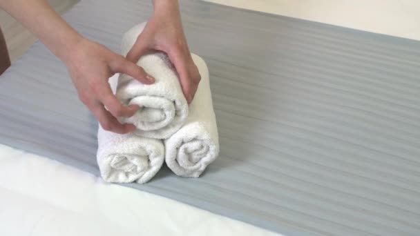 Chambermaid laittaa puhtaat pyyhkeet sängylle hotellihuoneessa, lähikuva - Materiaali, video