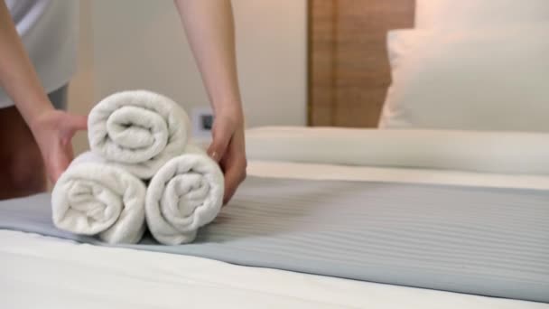 Oda hizmetçisi otel odasındaki yatağa temiz havlu koyuyor. - Video, Çekim