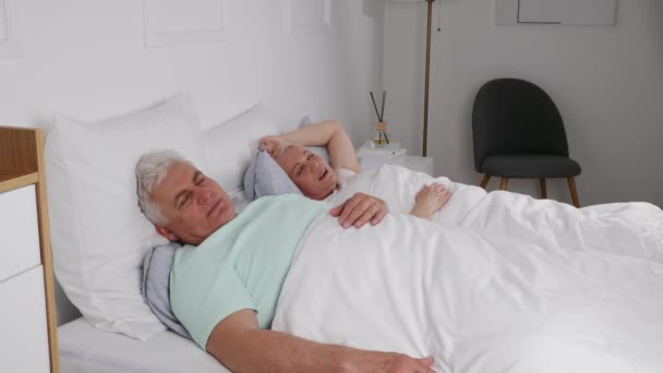 Érett irritált férfi horkoló feleséggel a hálószobában - Felvétel, videó