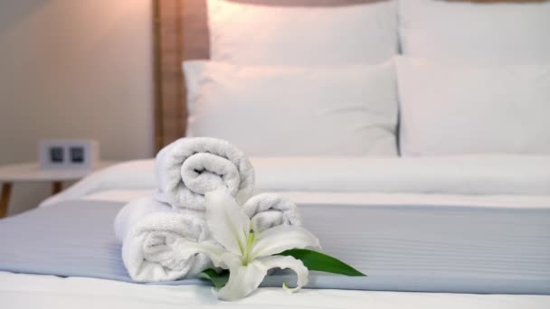 Chambermaid making bed in hotel room, focus on clean towels - Filmati, video