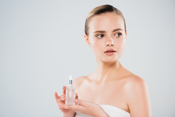 attractive young woman holding bottle with serum isolated on grey  - Фото, зображення