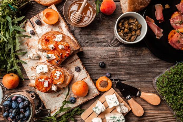 Μπρουσκέτα με ροδάκινο και μπλε τυρί σε ξύλινο φόντο, banner, catering μενού συνταγή θέση για κείμενο, top view. Ιταλική κουζίνα. - Φωτογραφία, εικόνα