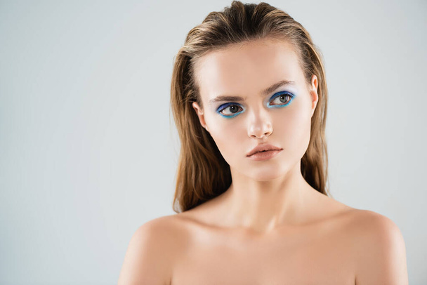 nude young woman with blue eye shadow looking away isolated on white - Fotografie, Obrázek