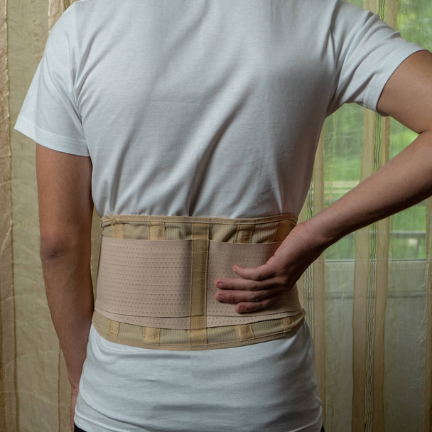 Orthopedic corset on the man body, back brace. The problem of scoliosis in adolescents, correction of posture with the help of a spinal corset. Lumbar corset for teens - Foto, Imagem