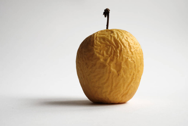 Manzana amarilla podrida con fondo blanco
 - Foto, imagen