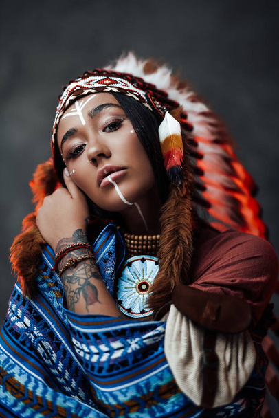 Beautiful American Indian girl with tattoo on hand in colorful traditional ethnic costume - Photo, Image