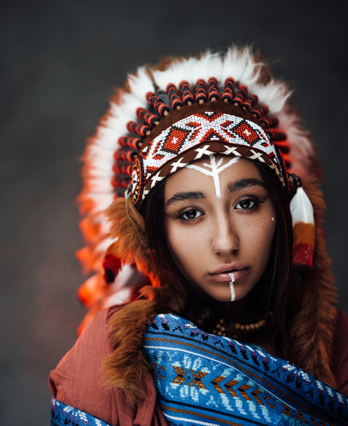 Portret van een mooie Amerikaanse Indiaanse vrouw in etnisch kostuum en traditionele make-up - Foto, afbeelding