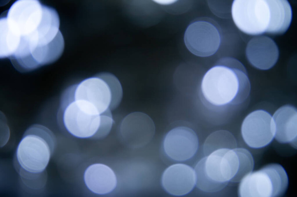 Blurred lights dark gray blue background. Abstract bokeh with soft light. Shiny festive christmas texture - Photo, image