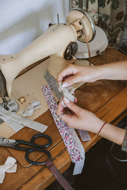 Ideas de pequeñas empresas, costurera local de negocios, vintage dressmaker espacio de trabajo. Diseñadora de moda femenina que hace accesorios para el cabello de tela artesanal, lazo, horquillas. Trabajo a medida en el escritorio con máquina de coser
. - Foto, Imagen