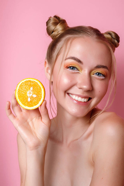 дівчина з білими зубами і апельсин на рожевому фоні
 - Фото, зображення