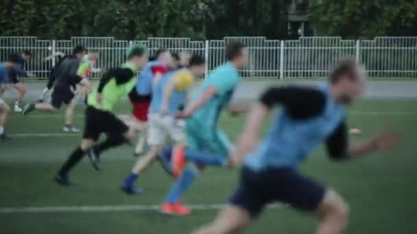 Die Spieler der Fußballmannschaft trainieren und laufen mit Tempo auf dem Fußballplatz. Zeitlupe. Nahaufnahme. Modell realisiert - Filmmaterial, Video