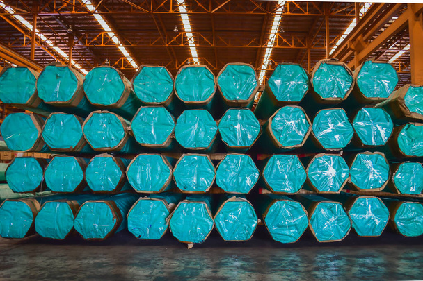 Emballages de tubes en acier empilés en couches à l'intérieur de la zone de stockage du grand entrepôt de distribution. Opérations logistiques d'entrepôt sidérurgique. - Photo, image