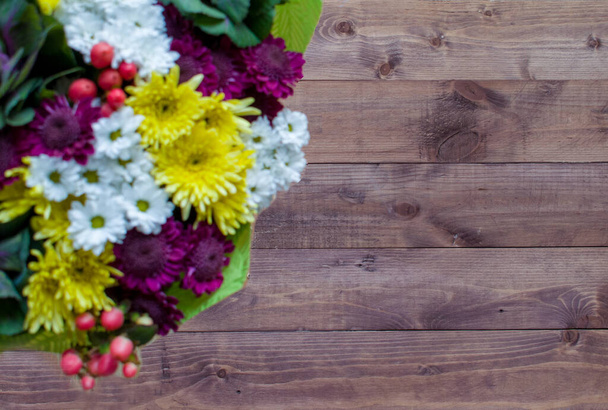 Ein Strauß Feldblumen auf braunem Holzgrund. Verschiedene Wildblumen. Draufsicht Home Dekoration. - Foto, Bild