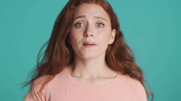 Egy aggódó vörös hajú lány portréja, aki remélhetőleg imádkozik az izolált kamera előtt. Kérlek mondd ki. - Felvétel, videó
