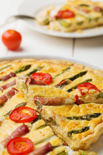 Tart with asparagus and tomatoes on white wooden background. - Foto, Imagen