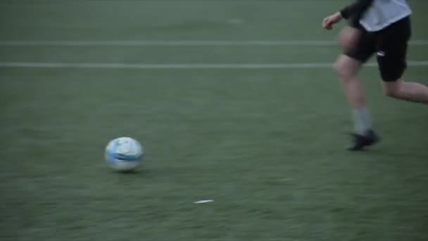 Fußballmannschaften beim Training. Der Fußballer geht mit dem Ball um die Abwehr herum auf das Tor zu und trifft. Nahaufnahme - Filmmaterial, Video