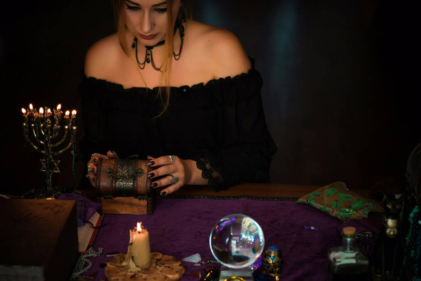  Mulher cartomante em um Tarot cartas, Conceito de previsões, rituais mágicos e elementos wicca em uma mesa
 - Foto, Imagem