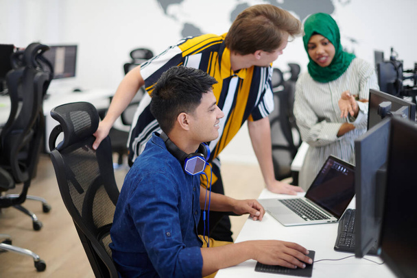 Multiethnic startup business team Arabian woman wearing a hijab on meeting in modern open plan office interior brainstorming, working on laptop and desktop computer - Φωτογραφία, εικόνα