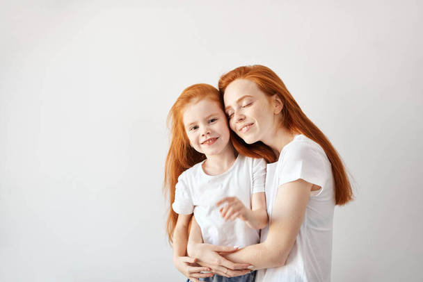 Beautiful young red haired mother hugging her cute little baby. - Foto, Imagem